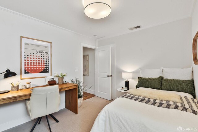 bedroom with light carpet and built in desk