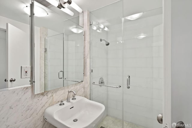 bathroom featuring tile walls, tasteful backsplash, an enclosed shower, and sink