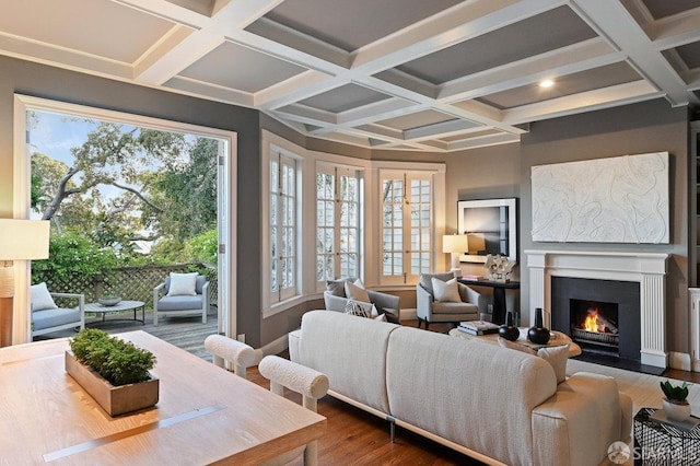 living room featuring dark wood-style flooring, beamed ceiling, coffered ceiling, and a fireplace with flush hearth
