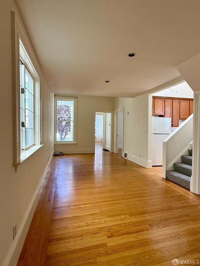 3543-3545 24th St, San Francisco, CA 94110 - unfurnished living room with light wood-type flooring, baseboards, and stairway