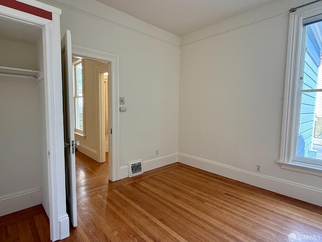 3543-3545 24th St, San Francisco, CA 94110 - unfurnished bedroom with light wood finished floors, baseboards, multiple windows, and a closet