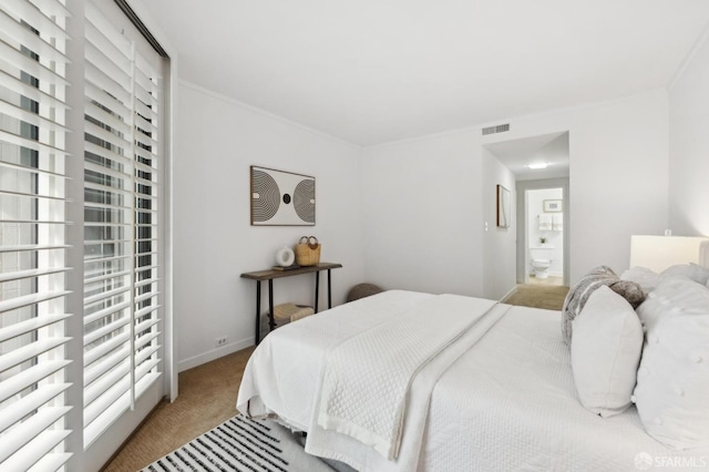 bedroom featuring carpet floors, ensuite bath, visible vents, and baseboards