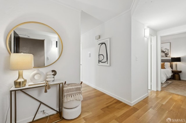 corridor featuring light wood-type flooring and baseboards