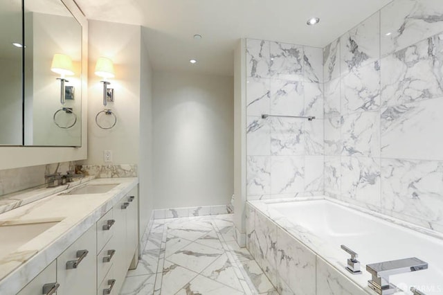 bathroom featuring double vanity, a tub with marble appearance, recessed lighting, and a sink