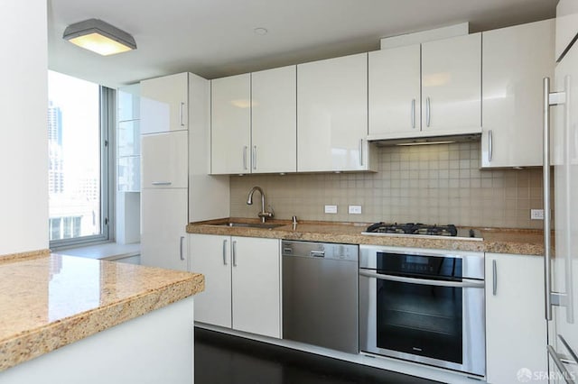 kitchen featuring stainless steel appliances, white cabinets, and light countertops