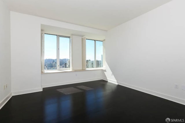 unfurnished room featuring baseboards