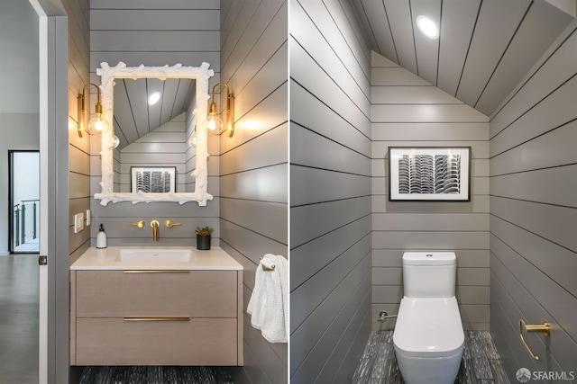 half bathroom with lofted ceiling, toilet, and vanity