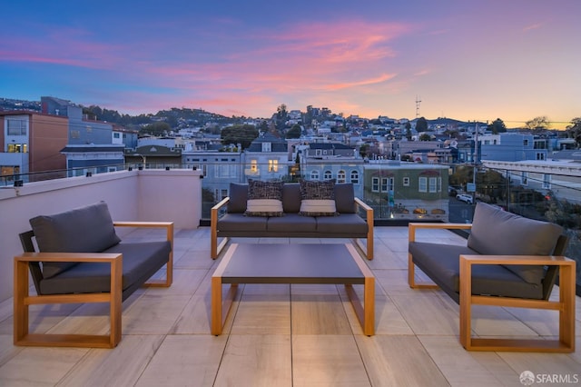 patio terrace at dusk with a balcony and an outdoor hangout area