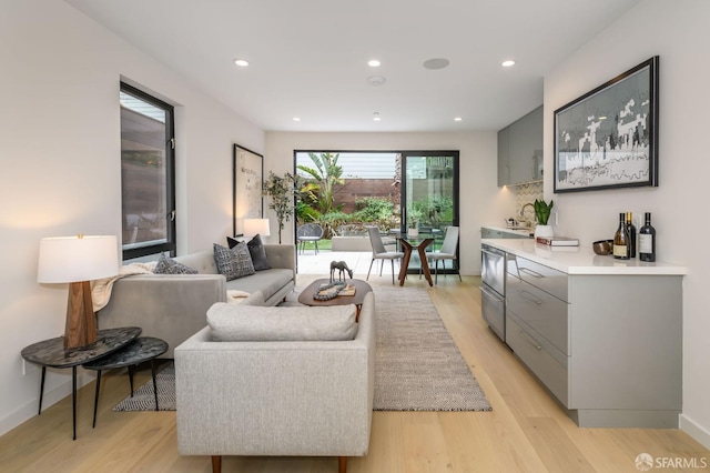 living room with light wood-type flooring, baseboards, and recessed lighting