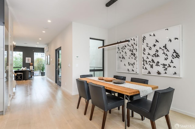 dining space featuring light wood finished floors, baseboards, and recessed lighting