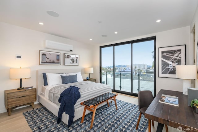 bedroom with access to outside, light wood-style flooring, an AC wall unit, and recessed lighting