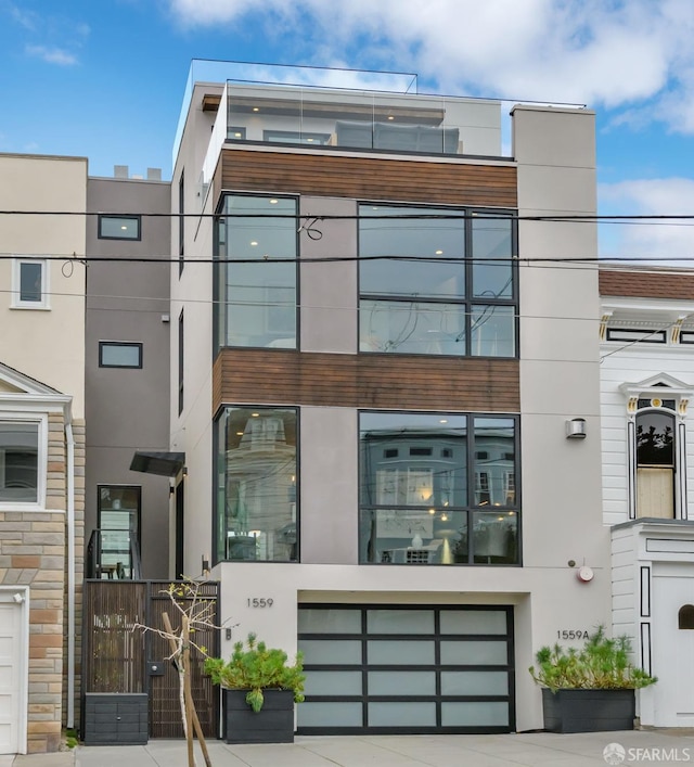 exterior space with a garage, concrete driveway, and stucco siding