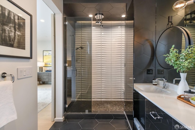 bathroom featuring tile patterned flooring, a tile shower, and vanity