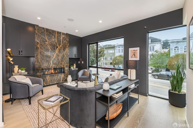 living area featuring light wood-style floors, recessed lighting, and a fireplace