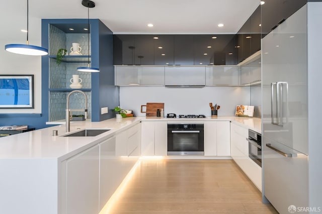 kitchen featuring black oven, a sink, high end refrigerator, and modern cabinets