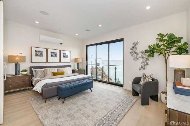 bedroom with recessed lighting, light wood finished floors, access to outside, and a wall mounted air conditioner