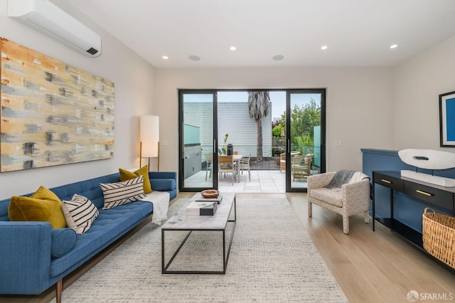 living room featuring a wall unit AC, light wood-style floors, and recessed lighting