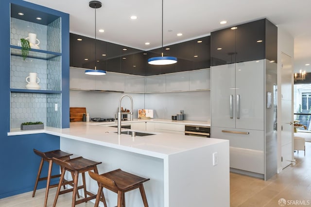 kitchen featuring open shelves, modern cabinets, a kitchen breakfast bar, pendant lighting, and a sink