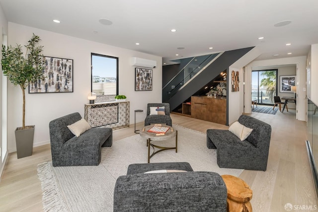 living room featuring a dry bar, recessed lighting, light wood-style flooring, a wall mounted air conditioner, and stairs