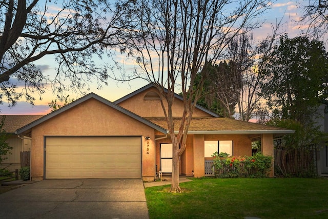 ranch-style house with a garage, concrete driveway, a lawn, and stucco siding