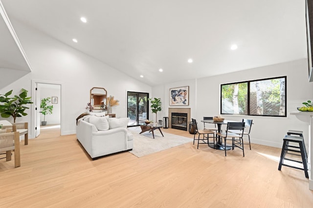 living area with light wood-type flooring, plenty of natural light, recessed lighting, and a glass covered fireplace