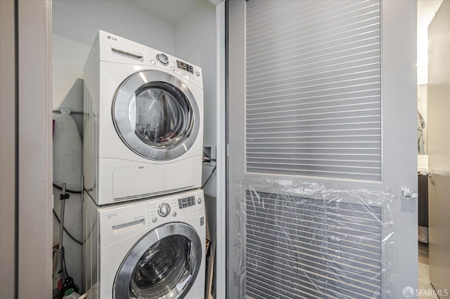 clothes washing area featuring stacked washer / dryer