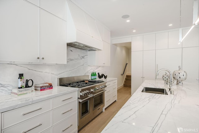 3537 23rd St Unit A, San Francisco, CA 94110 - kitchen with custom exhaust hood, double oven range, light stone counters, backsplash, and a sink