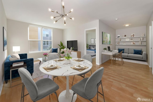 dining space featuring light wood-style flooring and a notable chandelier