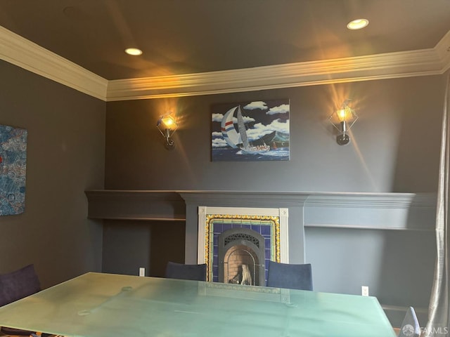 unfurnished dining area featuring a tiled fireplace and crown molding