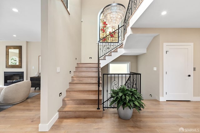 staircase featuring hardwood / wood-style floors and a notable chandelier