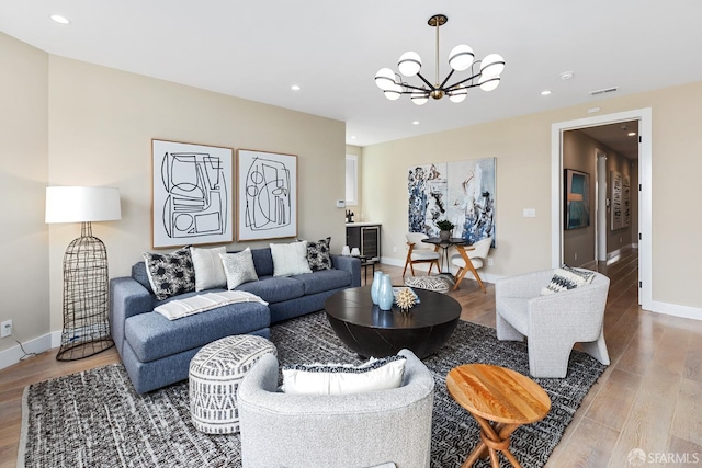 living room with light wood-type flooring and an inviting chandelier