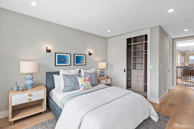 bedroom with light wood-type flooring and a closet