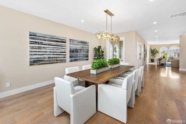 dining space featuring a notable chandelier and light hardwood / wood-style floors