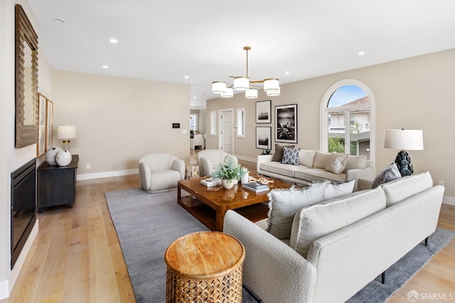 living room featuring light hardwood / wood-style flooring and a notable chandelier