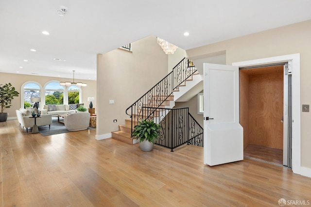 stairway featuring a notable chandelier and hardwood / wood-style floors