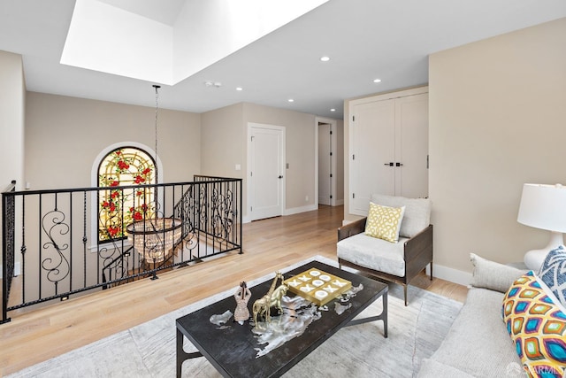 living room with light hardwood / wood-style flooring and a skylight