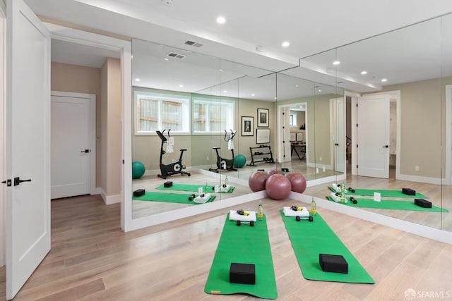 exercise area with light hardwood / wood-style flooring