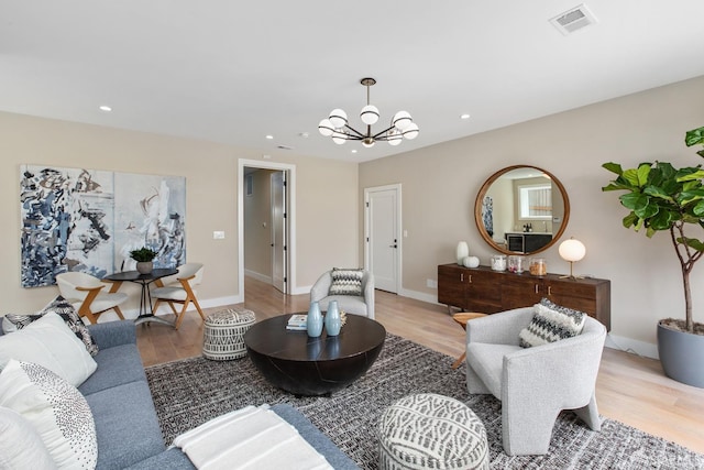 living room with an inviting chandelier and light wood-type flooring