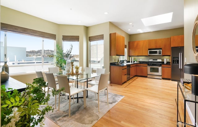 3310 19th St Unit 303, San Francisco, CA 94110 - kitchen with stainless steel range with gas stovetop, white microwave, brown cabinets, fridge with ice dispenser, and dark countertops