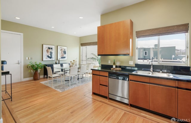 3310 19th St Unit 303, San Francisco, CA 94110 - kitchen featuring dishwasher, a sink, light wood-type flooring, dark countertops, and brown cabinets