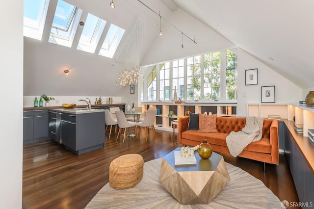 living room with dark hardwood / wood-style floors, a skylight, and high vaulted ceiling