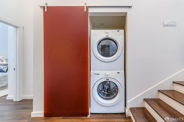 washroom featuring dark wood-type flooring and stacked washer and clothes dryer