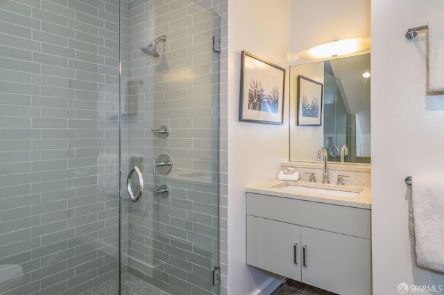 bathroom with vanity and a shower with door