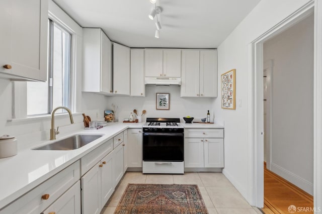 2065-2067 Turk Blvd, San Francisco, CA 94115 - kitchen with white range with gas stovetop, under cabinet range hood, a sink, light countertops, and white cabinetry