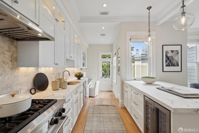 2531 Gough St, San Francisco, CA 94123 - kitchen with under cabinet range hood, wine cooler, gas stove, glass insert cabinets, and light wood-type flooring