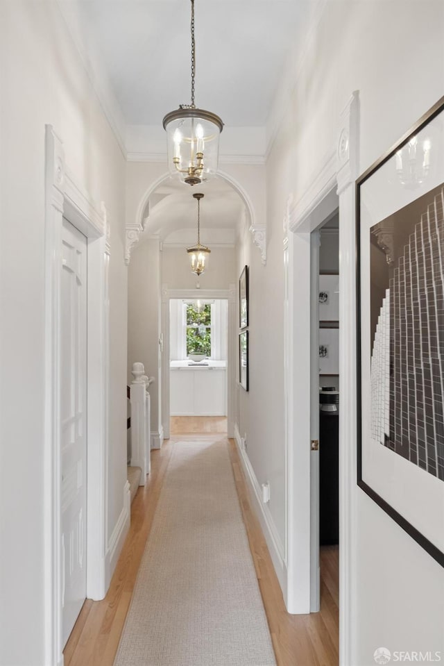 2531 Gough St, San Francisco, CA 94123 - hallway featuring light wood-type flooring, a chandelier, arched walkways, and crown molding