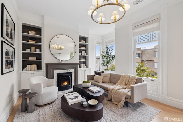 2531 Gough St, San Francisco, CA 94123 - living room featuring a chandelier, wood finished floors, built in shelves, and a high end fireplace