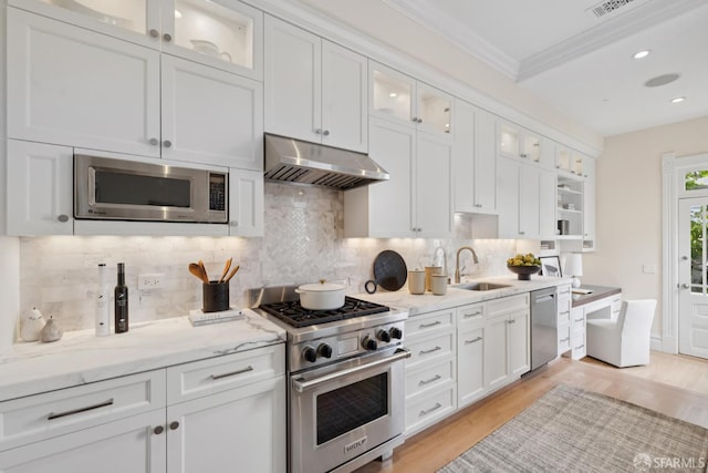 2531 Gough St, San Francisco, CA 94123 - kitchen featuring appliances with stainless steel finishes, under cabinet range hood, ornamental molding, white cabinetry, and tasteful backsplash