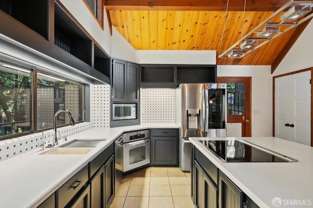 kitchen featuring light tile patterned flooring, appliances with stainless steel finishes, sink, and wood ceiling