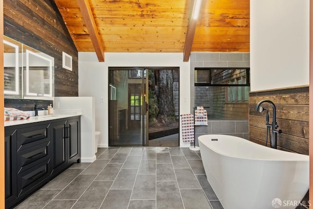 bathroom with a bathing tub, vanity, lofted ceiling with beams, and tile patterned floors